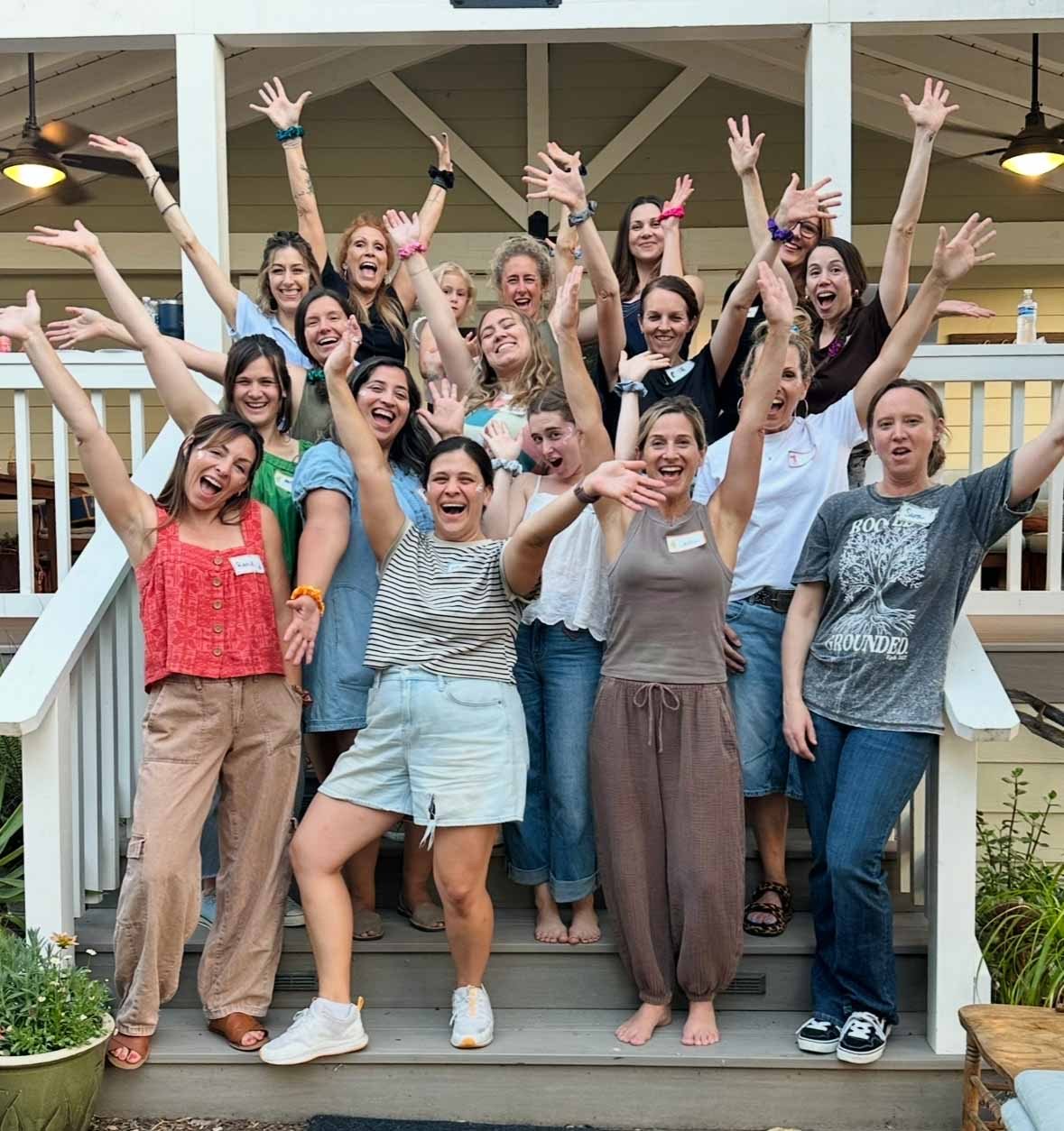 Group of women smiling together on porch steps