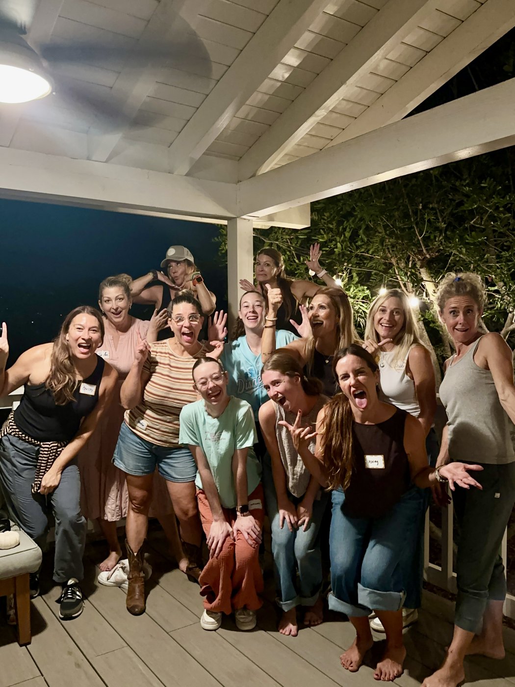 Group of women posing together on a porch at night